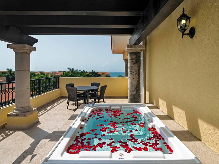 A private balcony with a a jacuzzi and seating area