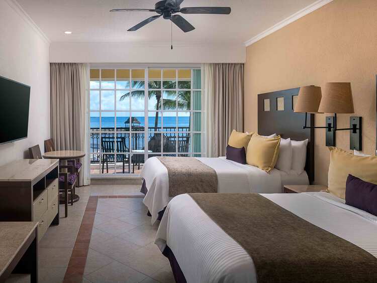 Dormitorio con una cama, TV de pantalla plana y balcón privado.